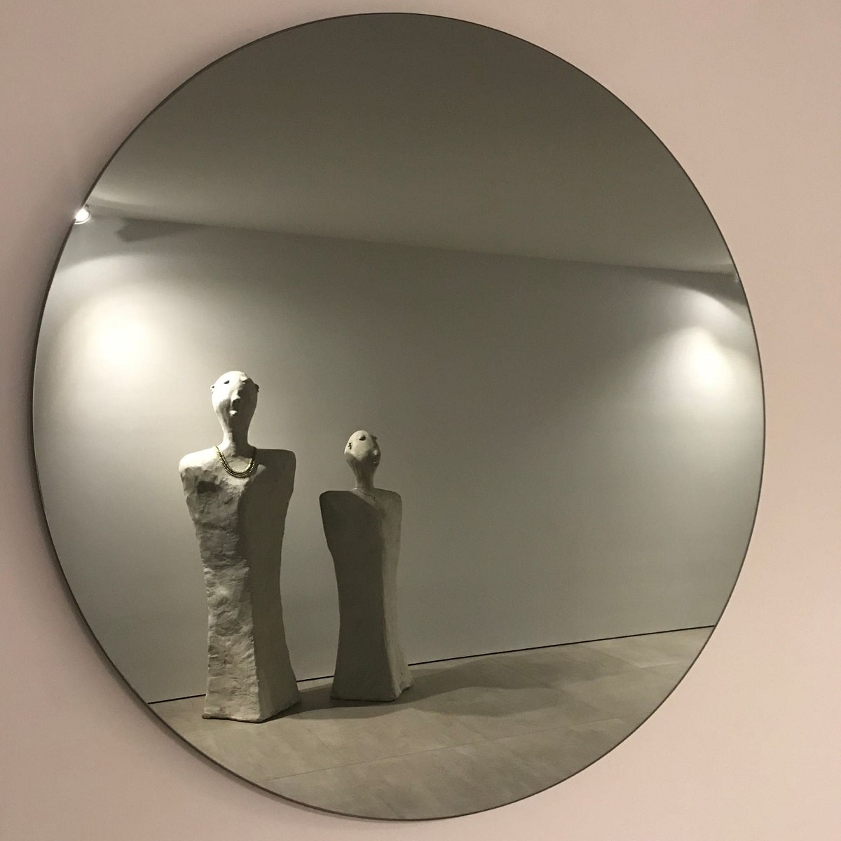 Home automation Brighton lovely circle mirror with two stone statues of people in the mirror